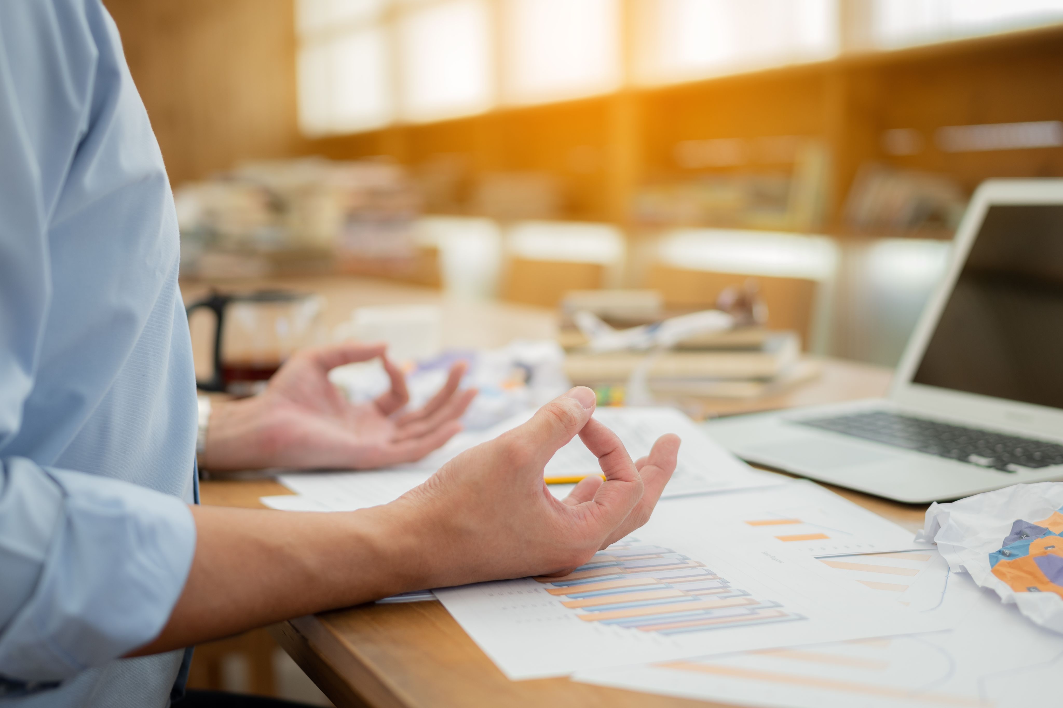 A person practicing meditation at their desk