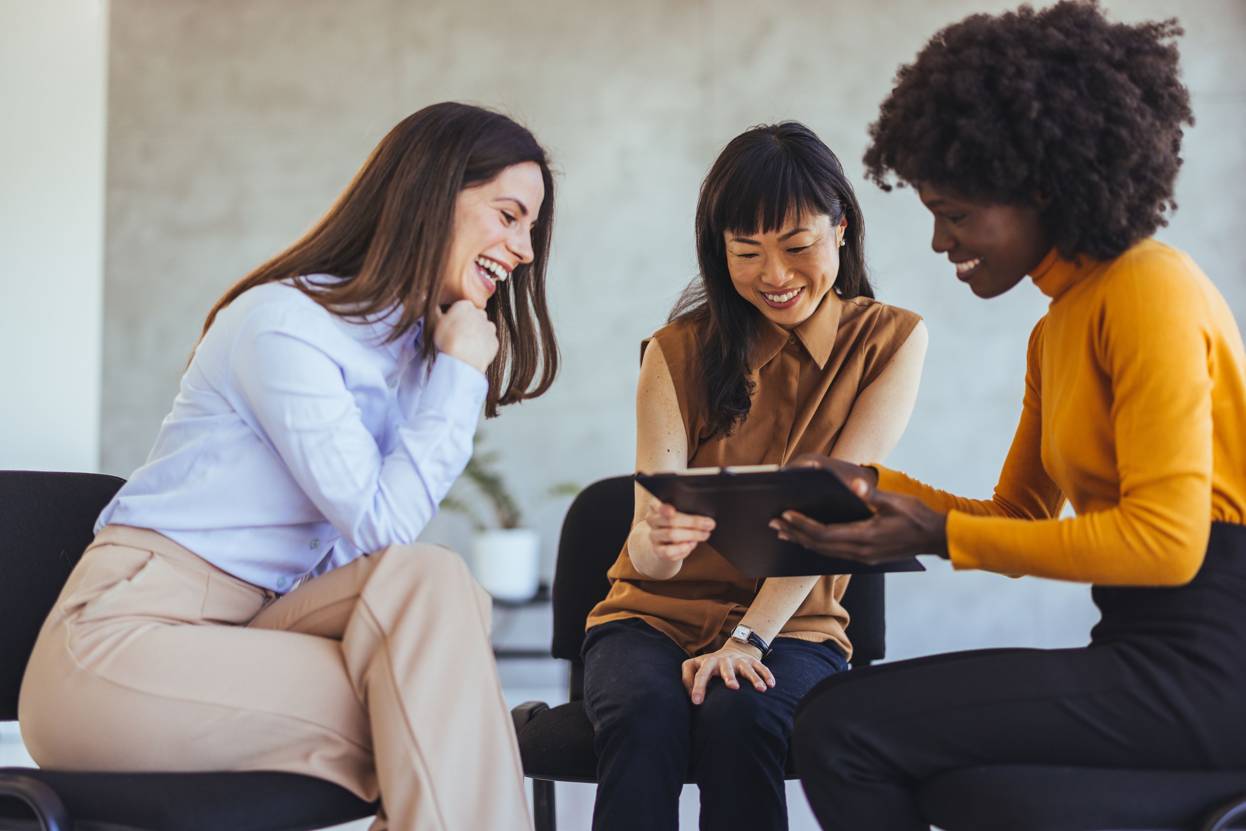 Women laughing and working on a project together