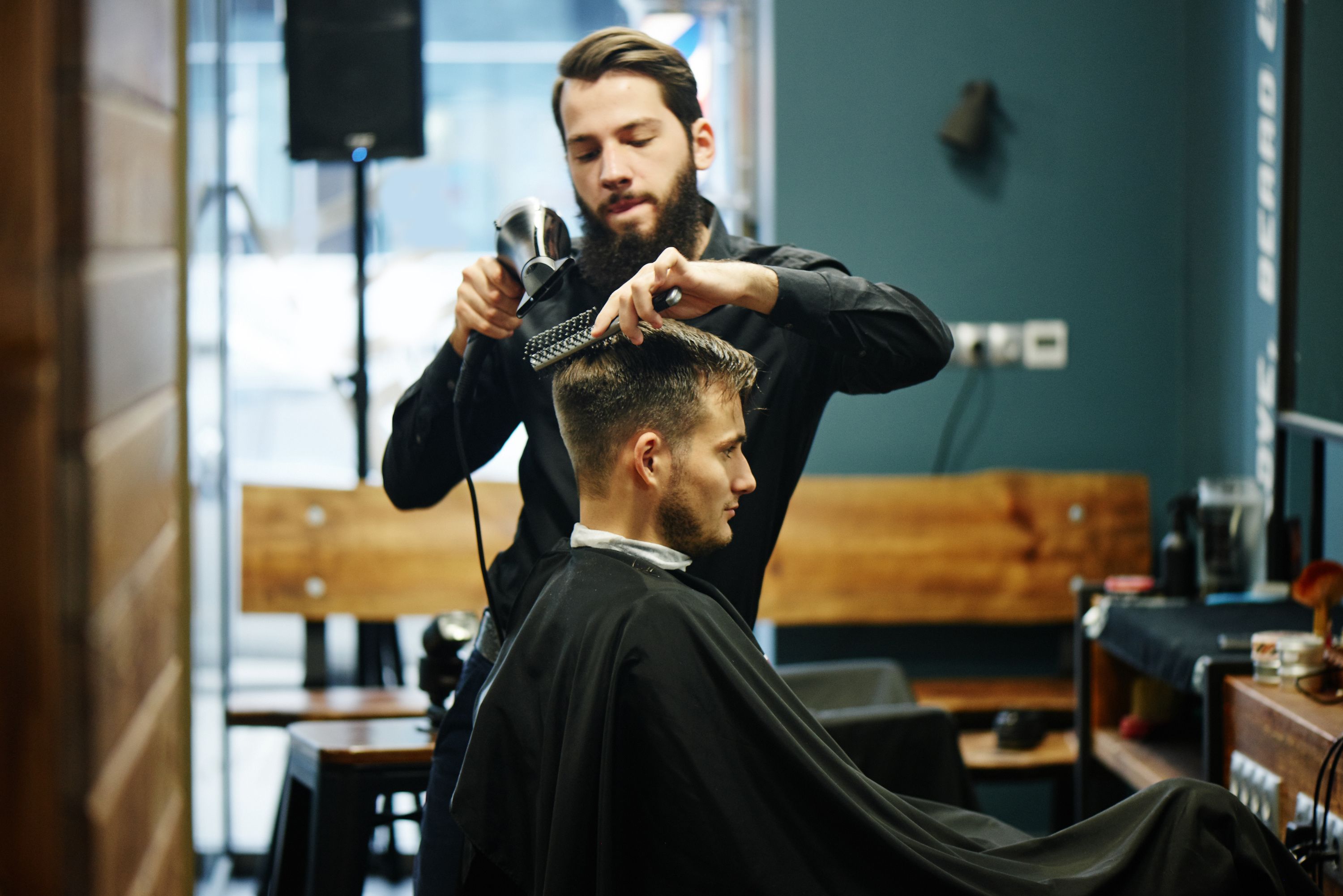 Young barber drying a client's hair - Copyright - amixstudio / Adobe Stock