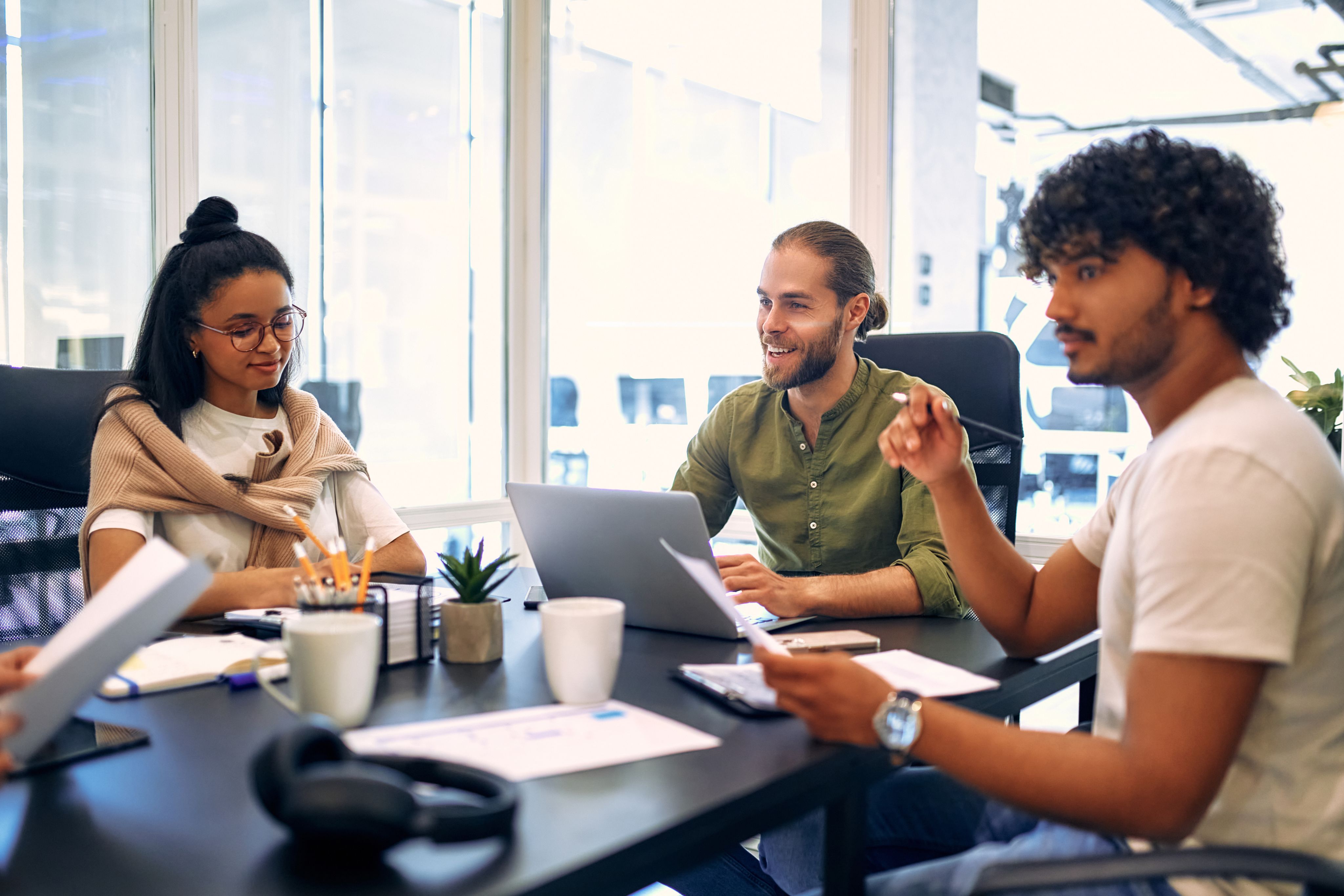 Group of young freelancers working in a co-working space - Copyright: Valerii Apetroaiei / Adobe Stock
