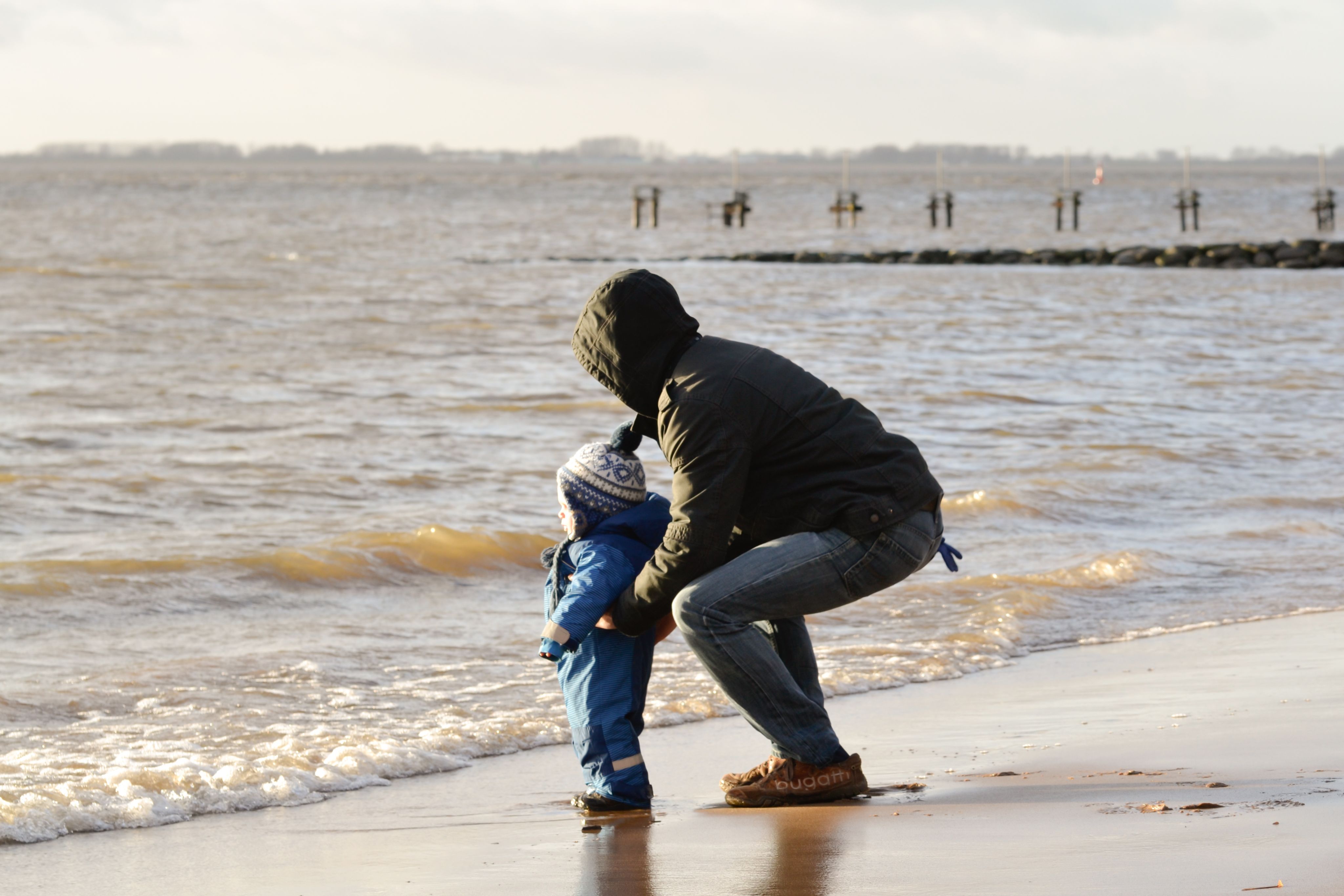 Father with toddler sun on the beach looking out at the waves - Copyright - Pics4u / Adobe Stock