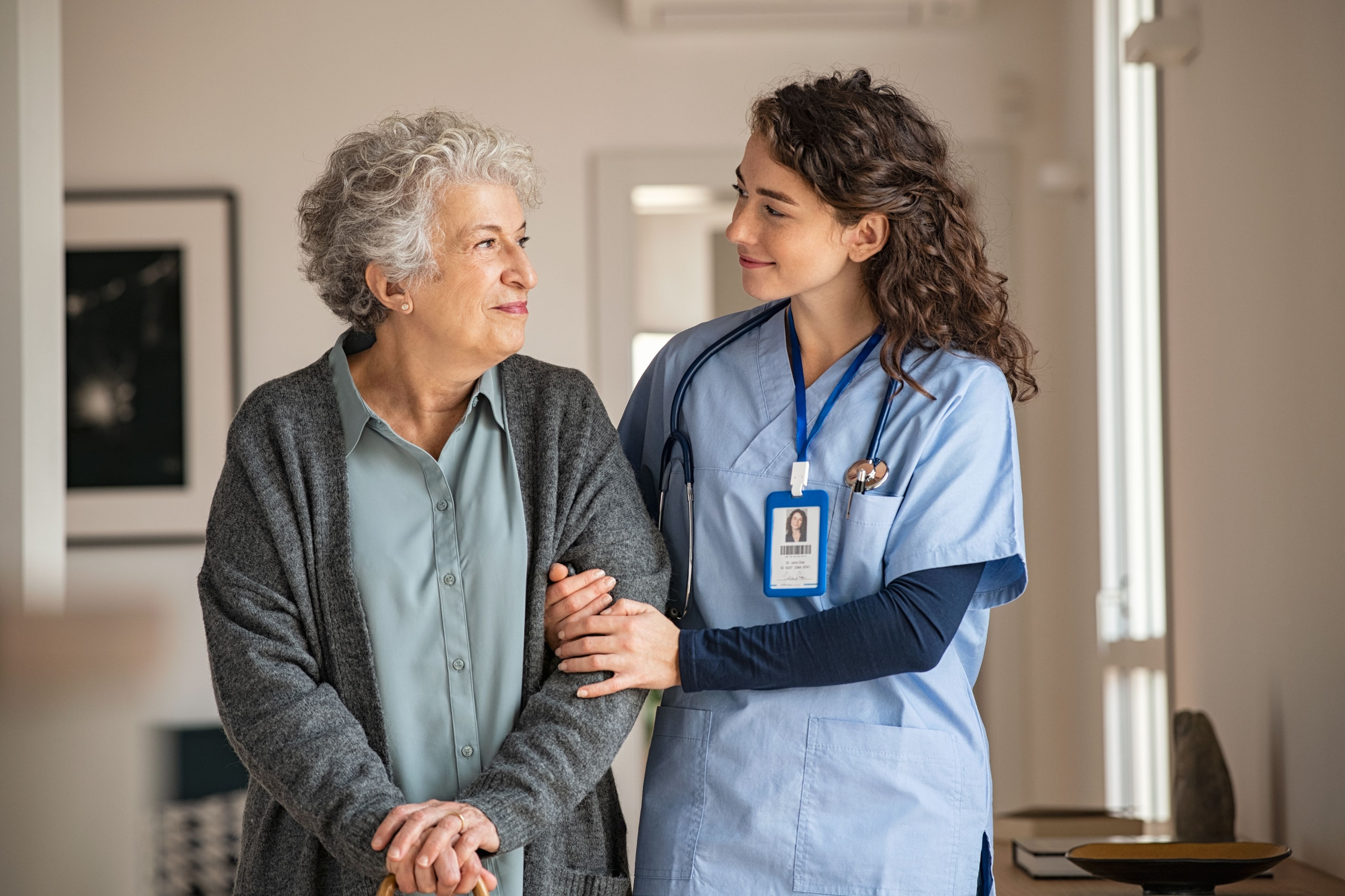 Young caregiver assists elderly woman in her home. Copyright - Rido / Adobe Stock