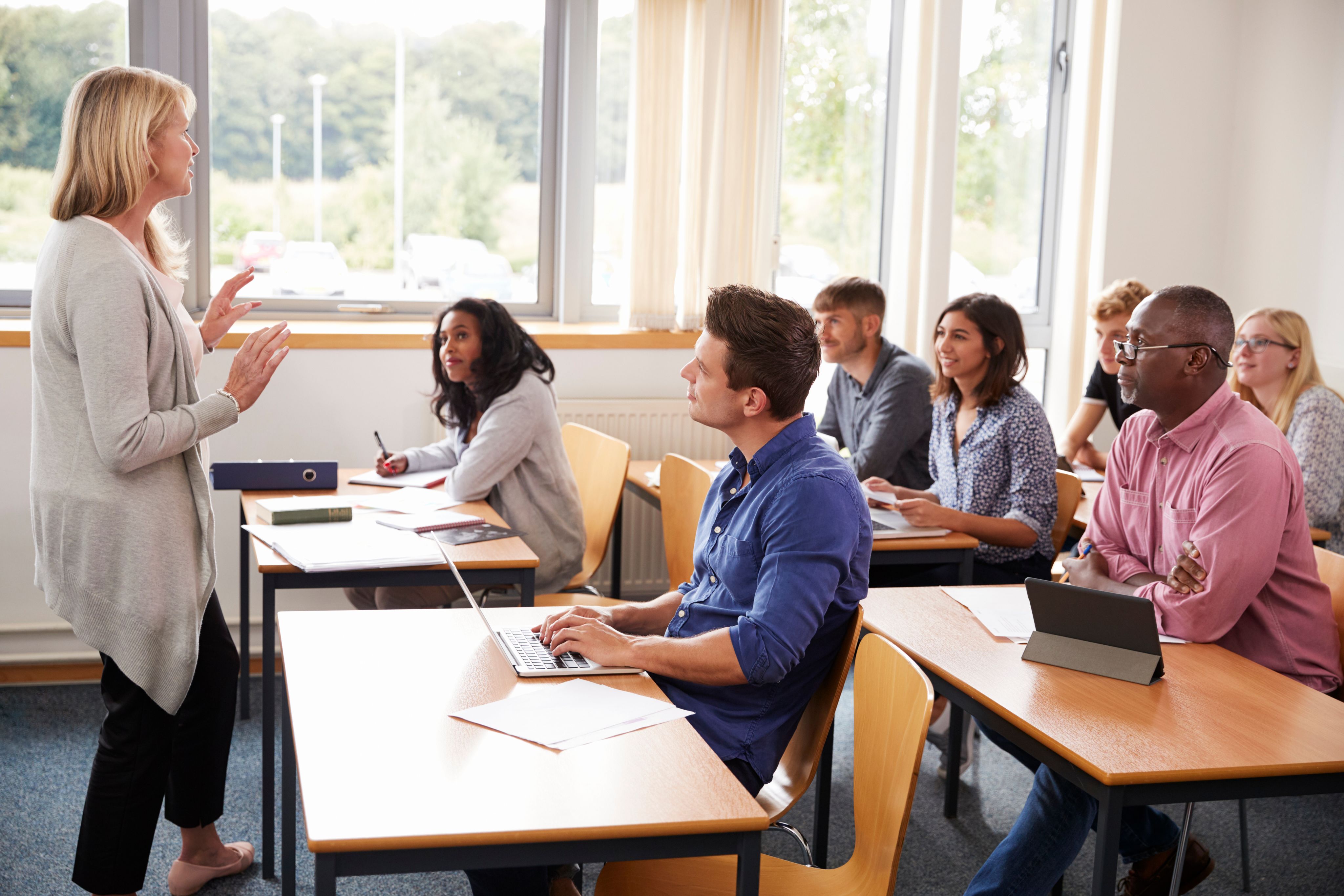 Female tutor teaching a group of mature students - Copyright - Monkey Business / Adobe Stock