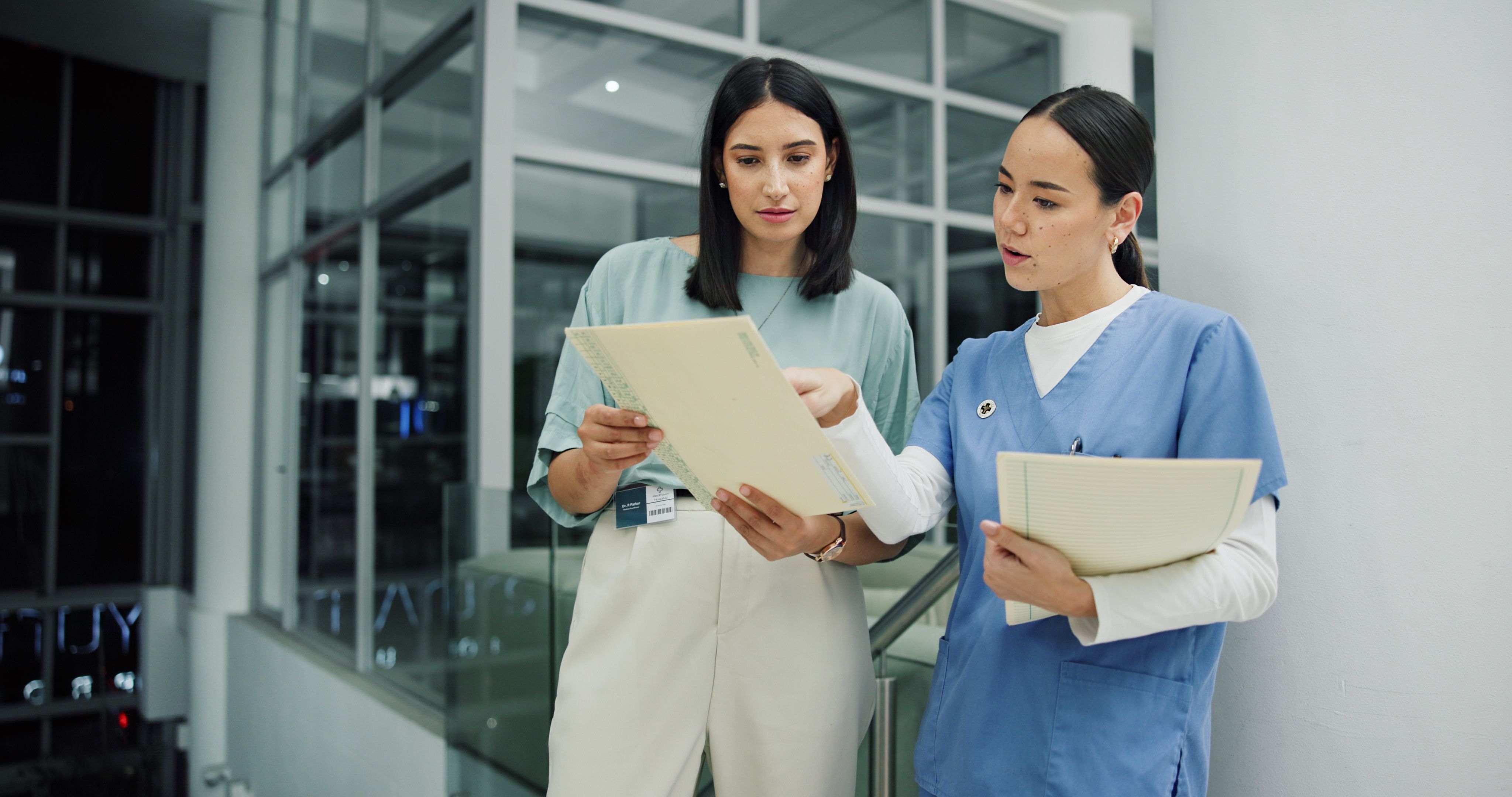 Female nurse looks over medical rec ords with a female clerical worker - Copyright - ChasingMagic25peopleimages.com / Adobe Stock