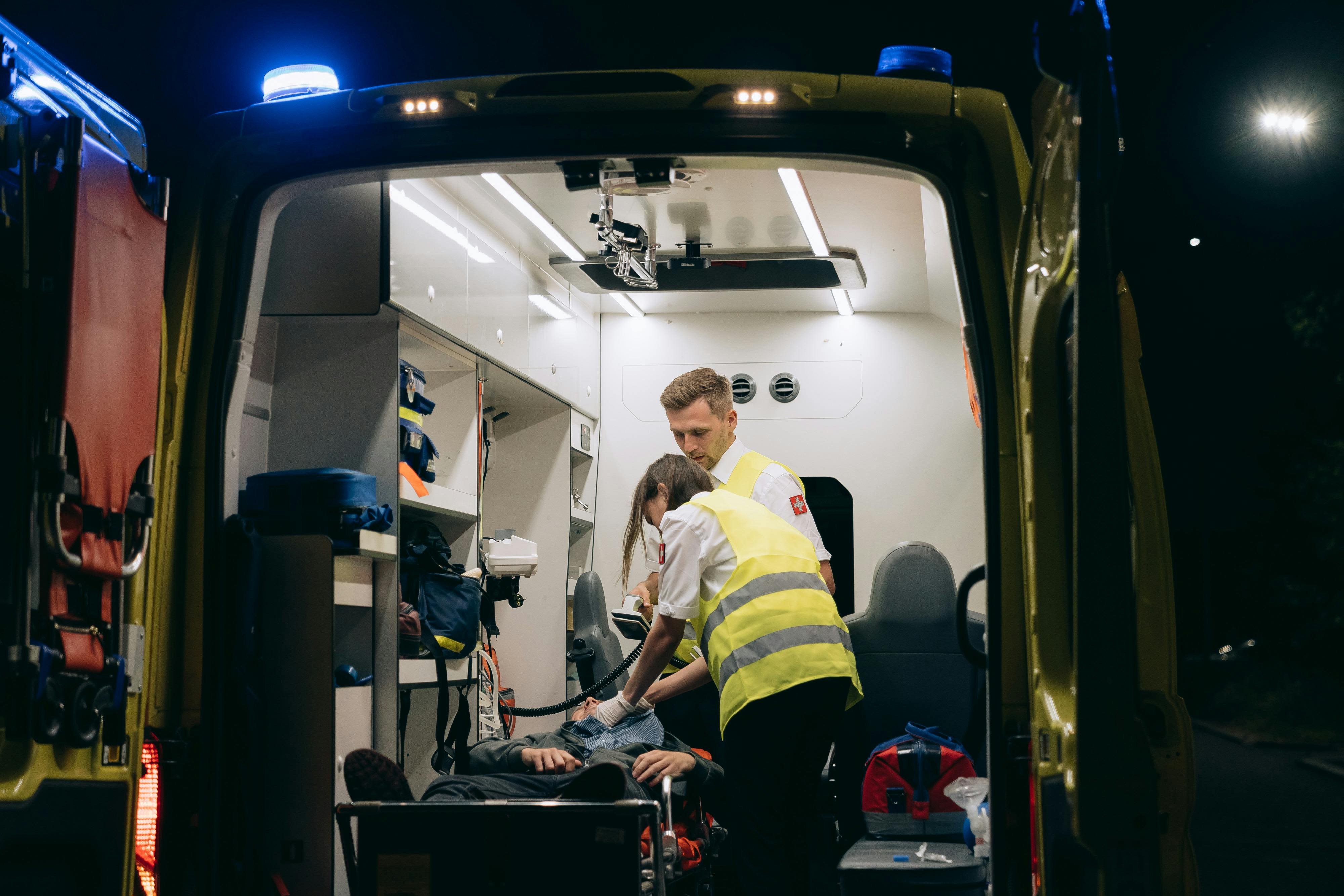 Paramedics attend to a patie nt inside an ambulance, providing emergency medical assistance at night. Photo by Mikhail Nilov on Pexels
