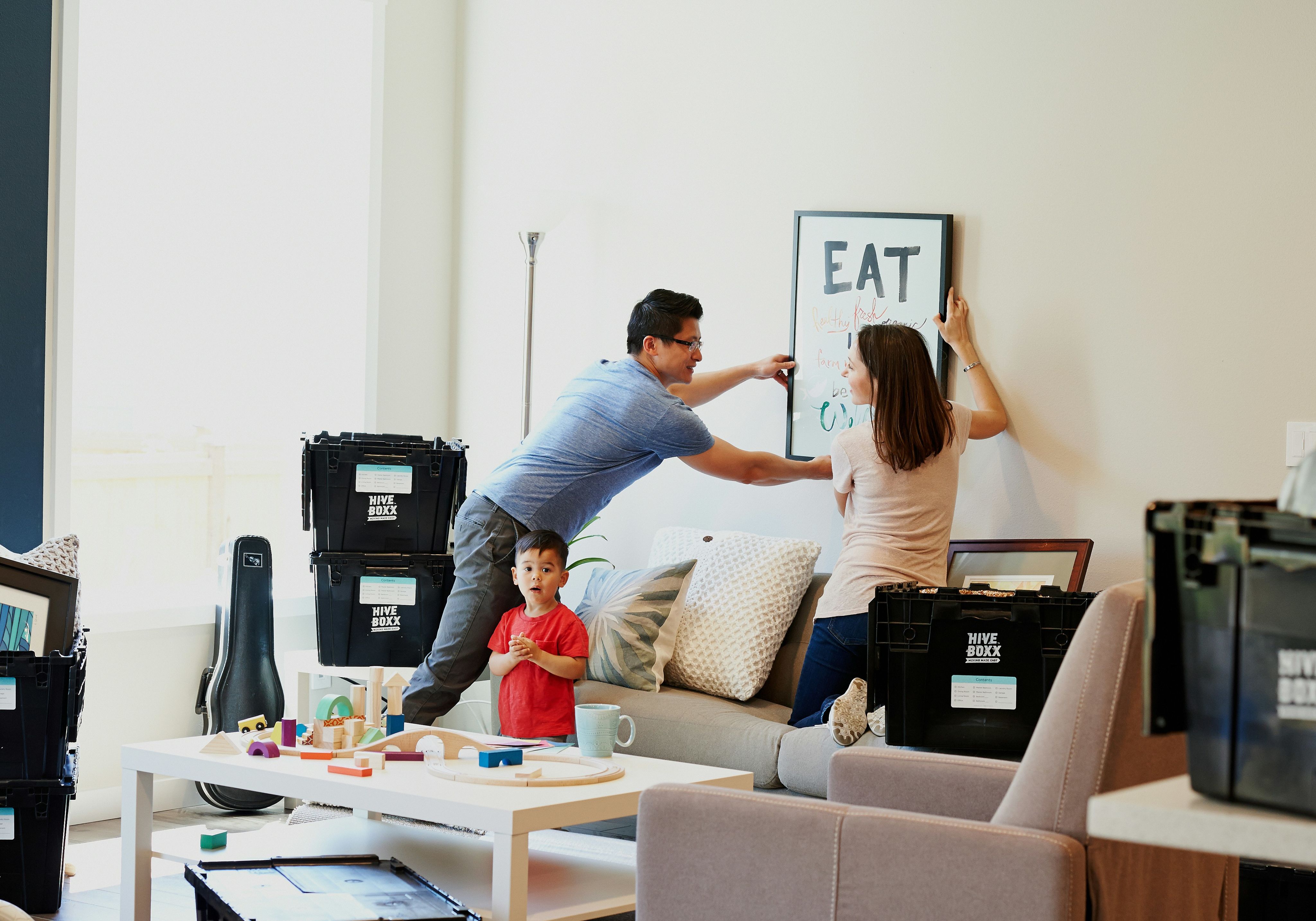 family moving into new apartment putting a picture on the wall