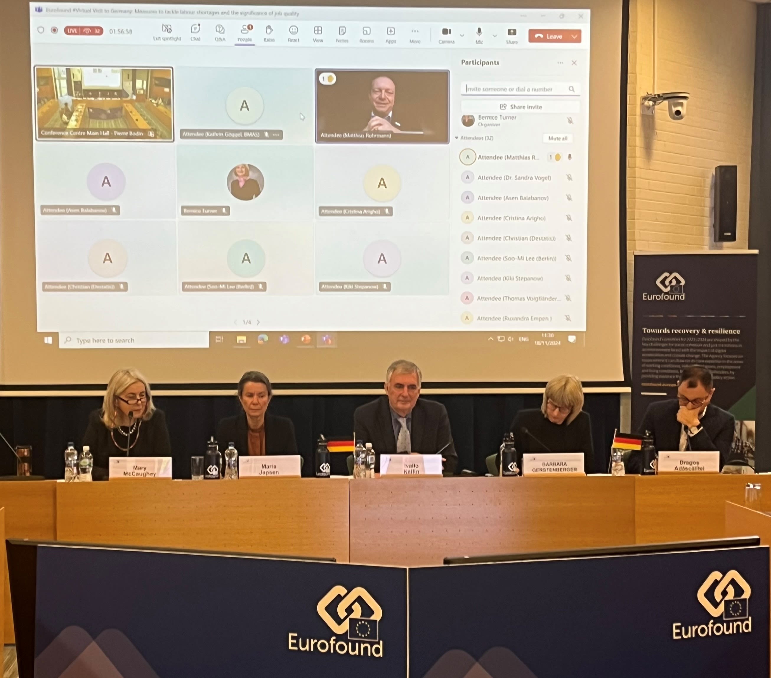 Eurofound staff members on a panel with a screen behind them showing participants of a Virtual visit via zoom