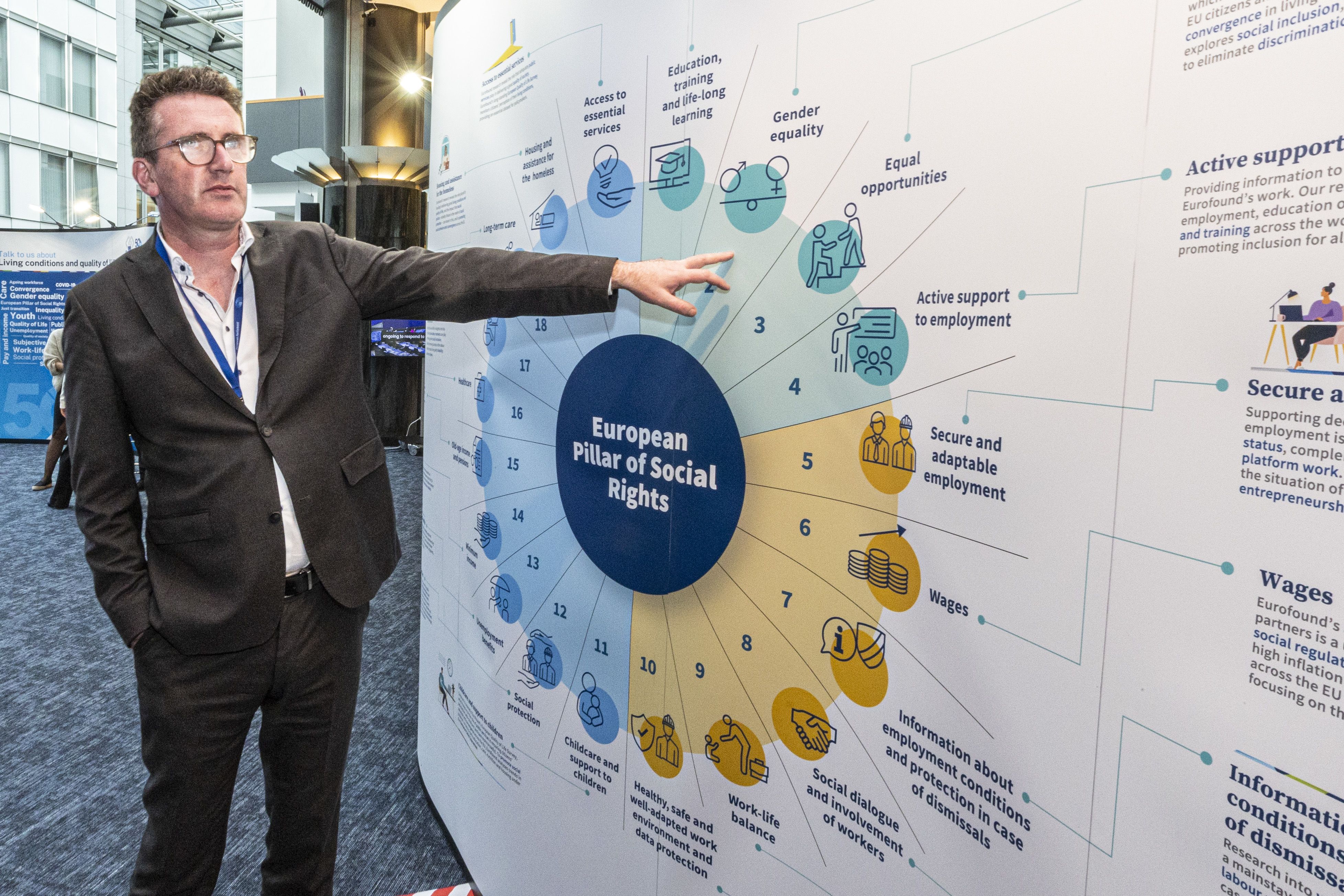 Member of the European Parliament Aodhán Ó Ríordáin at Eurofound exhibition and pointing to a sign on the European Pillar of Social Rights