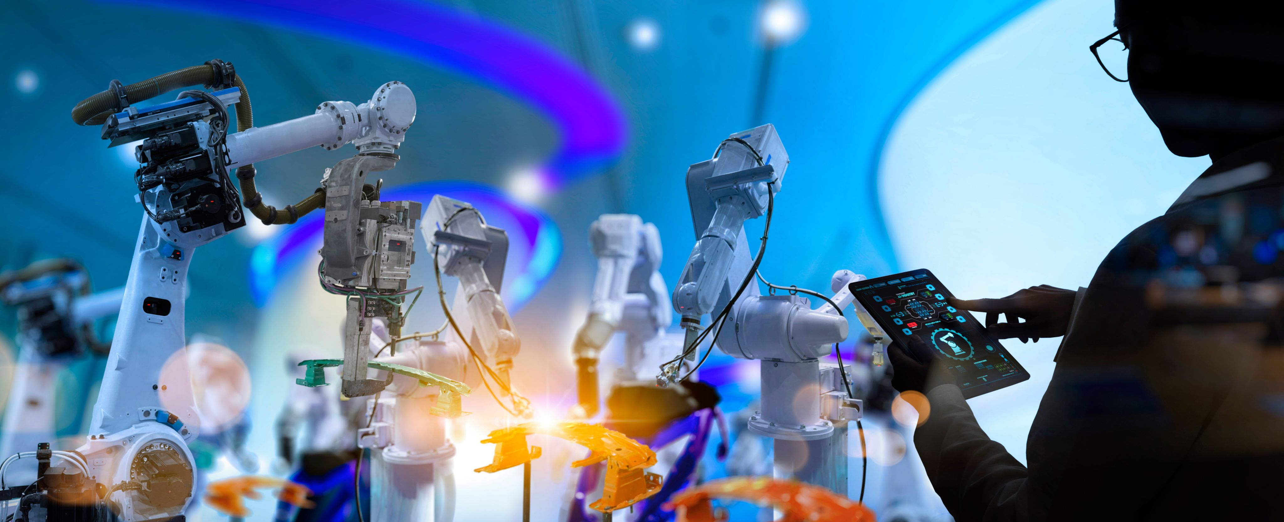 Robotic arms with a person controlling them with a tablet device