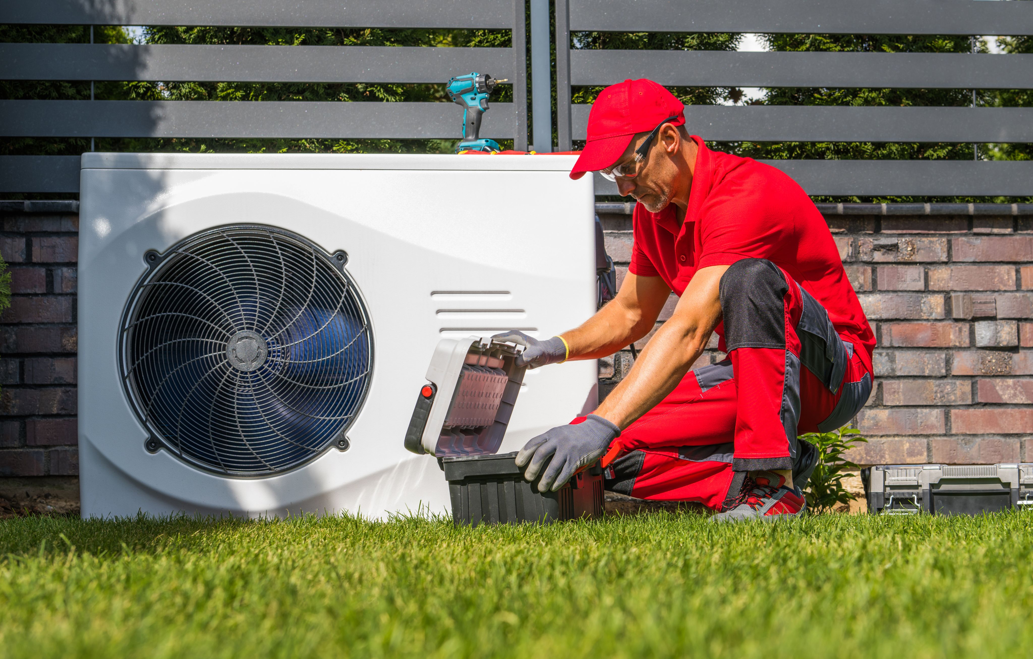 Man installing a heat pump in a garden