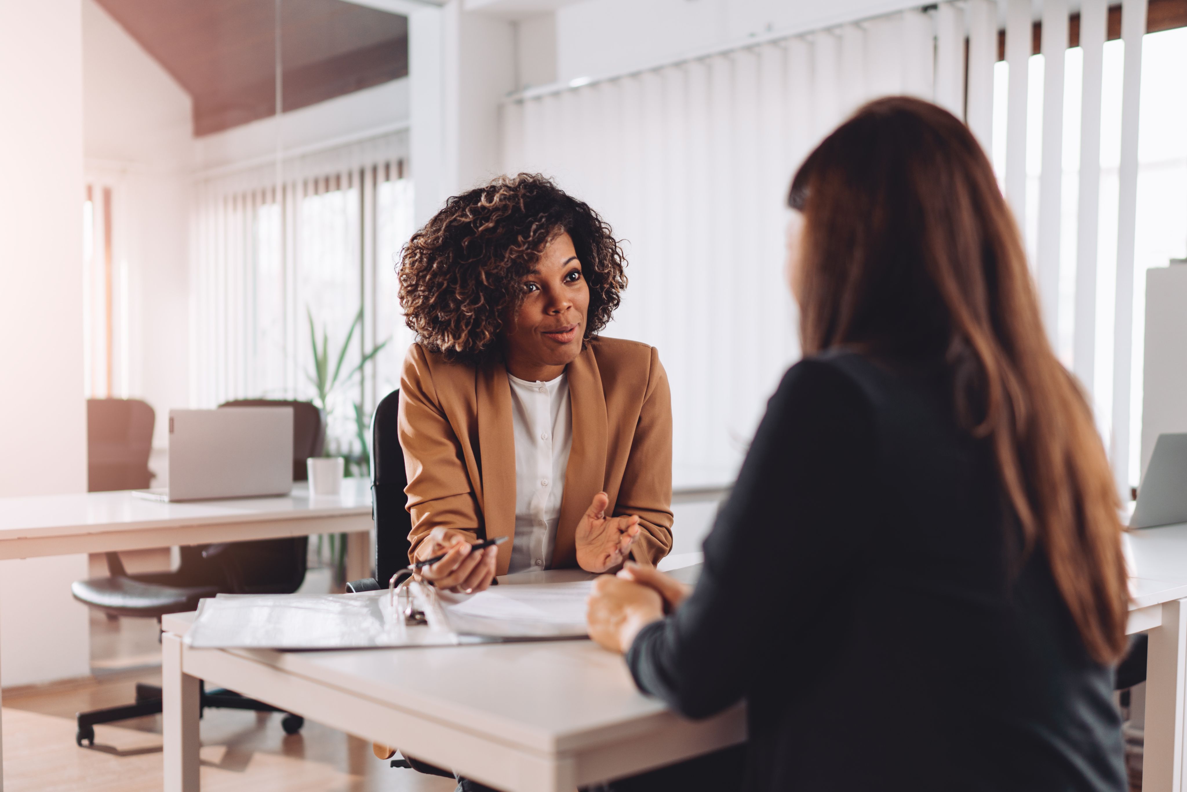two women sitting at a table discussing work