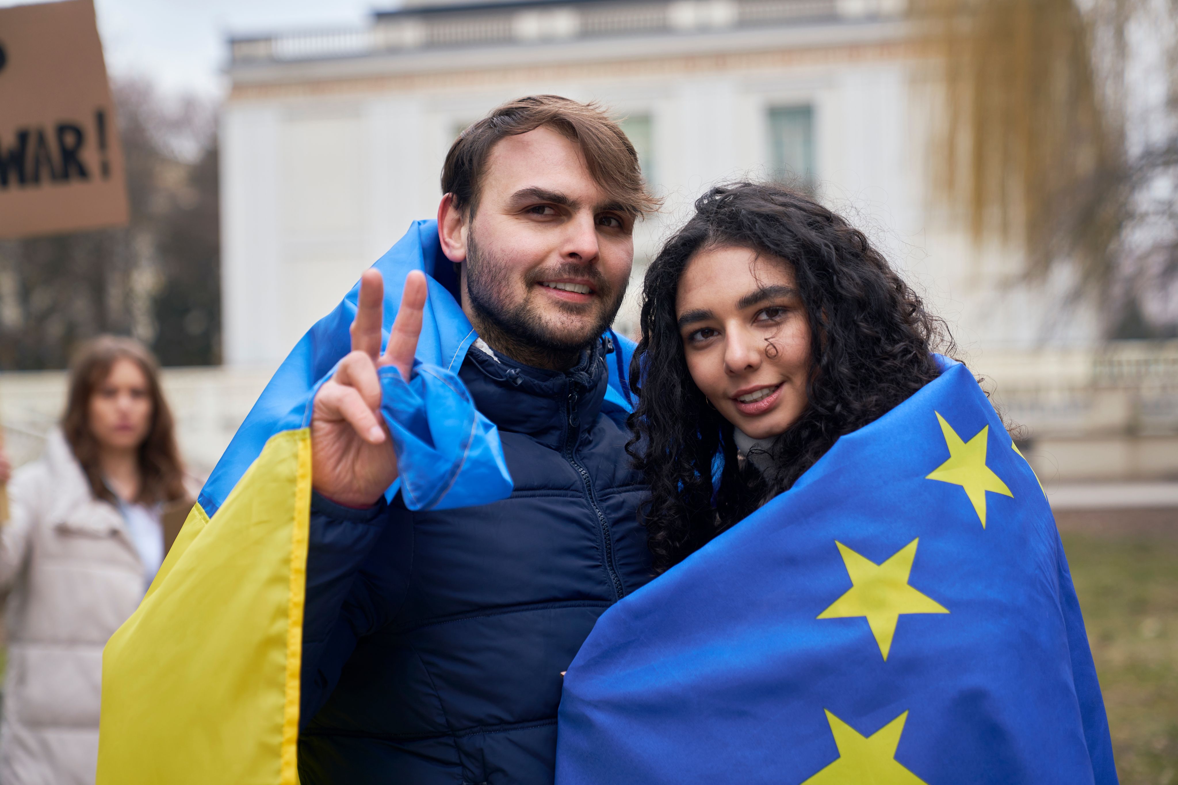 Man and woman draped in a Ukrainian flag