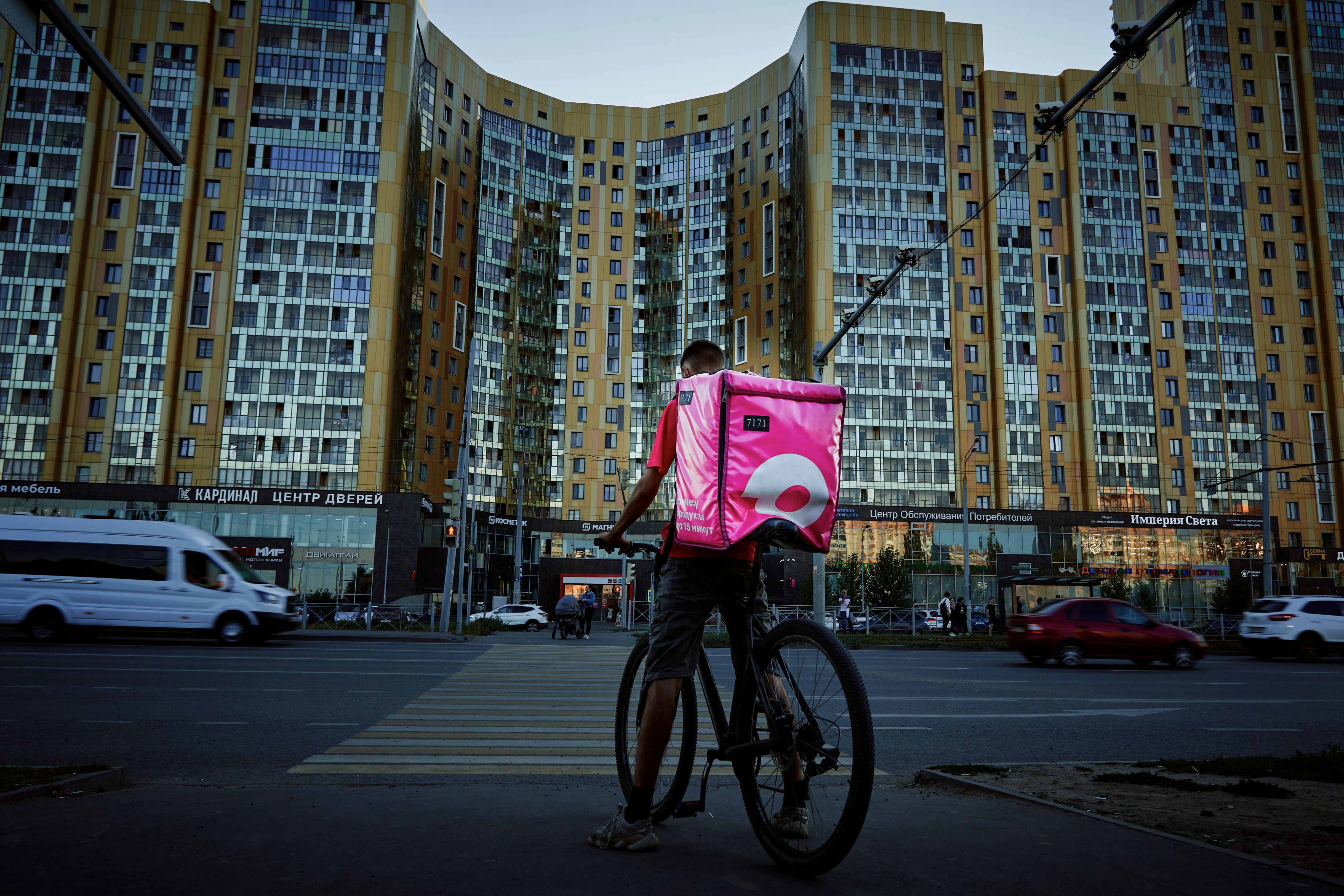 man in red shirt riding bicycle on road during daytime