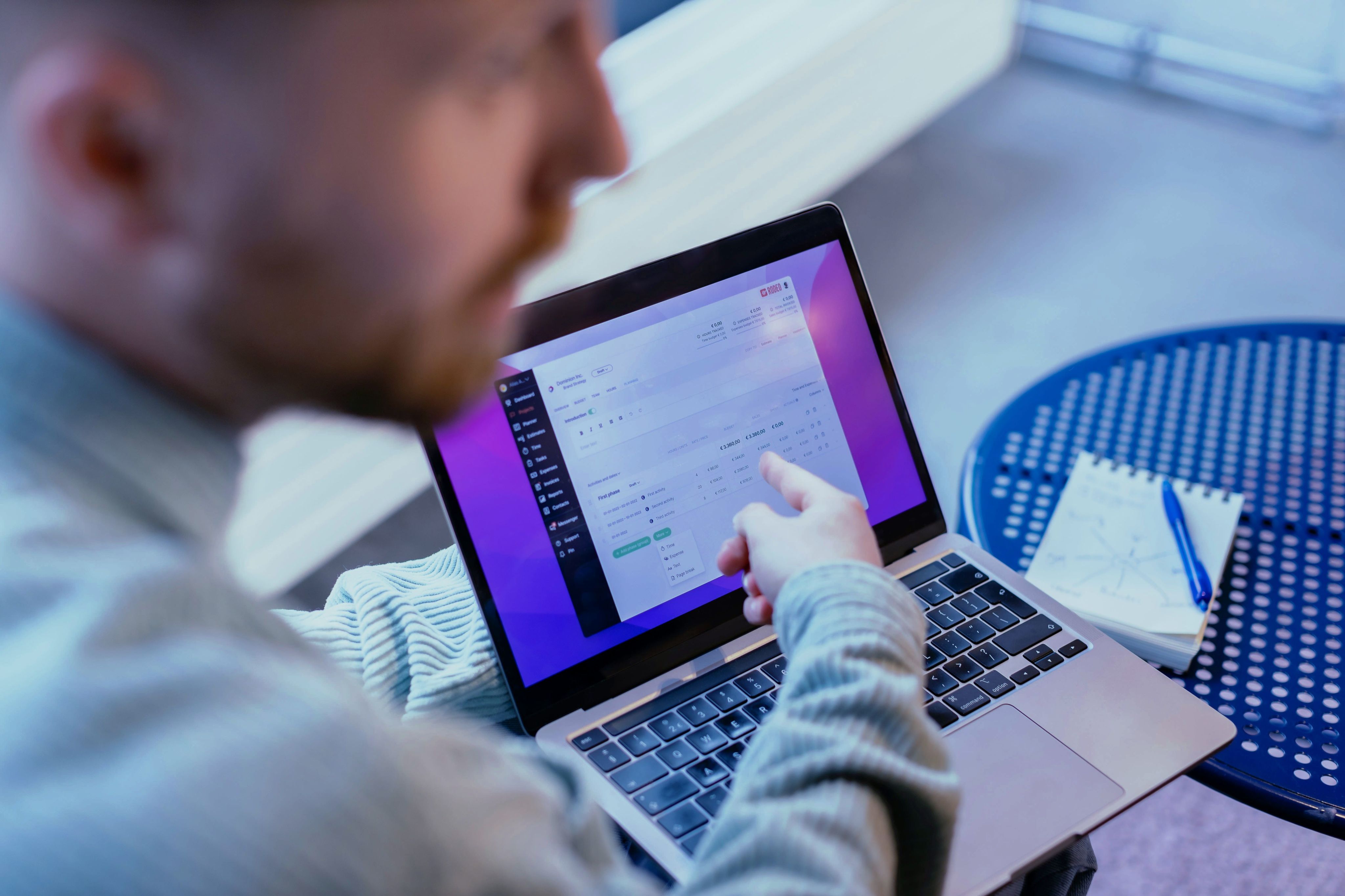 a man sitting at a table using a laptop computer