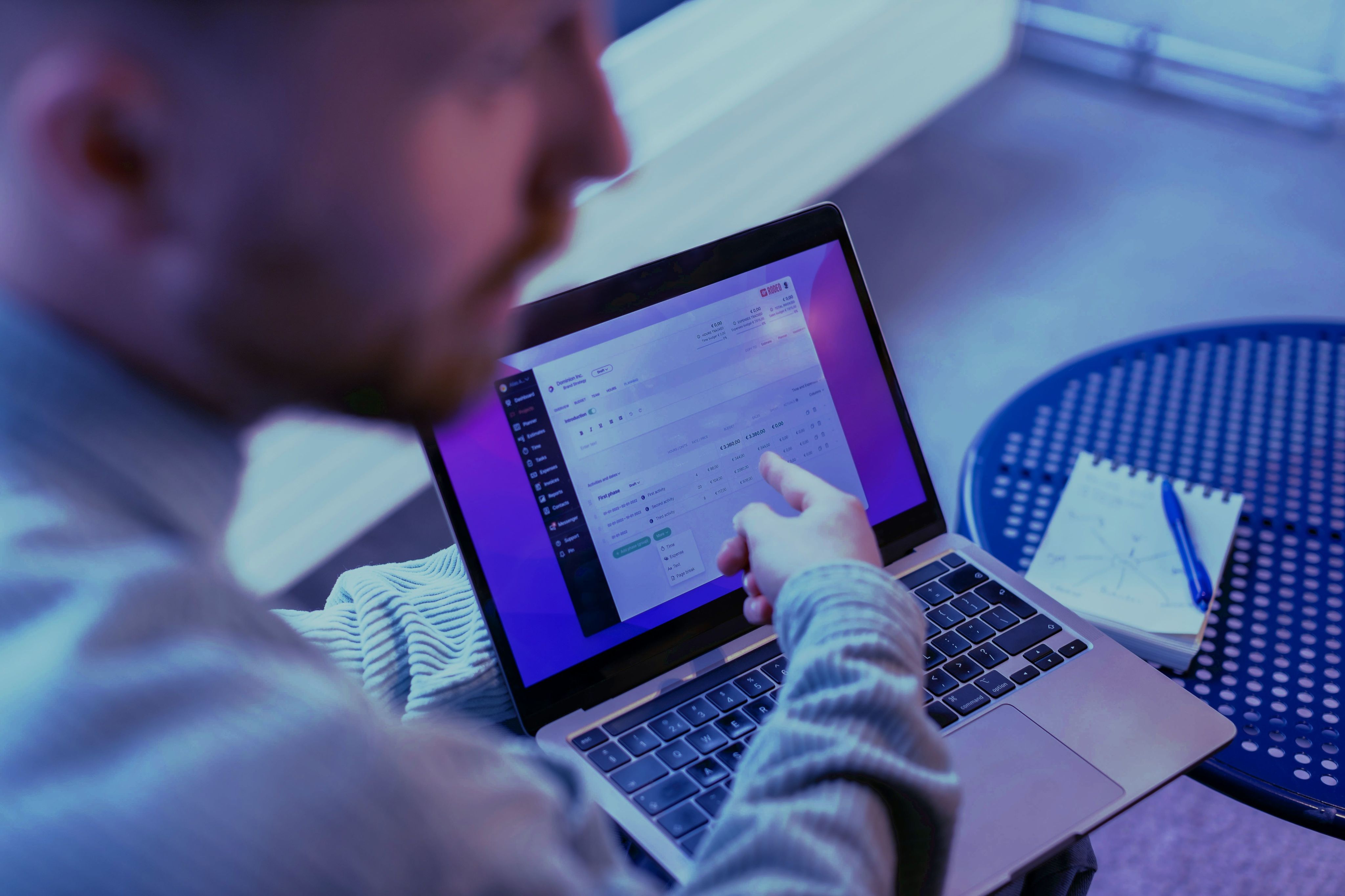 a man sitting at a table using a laptop computer